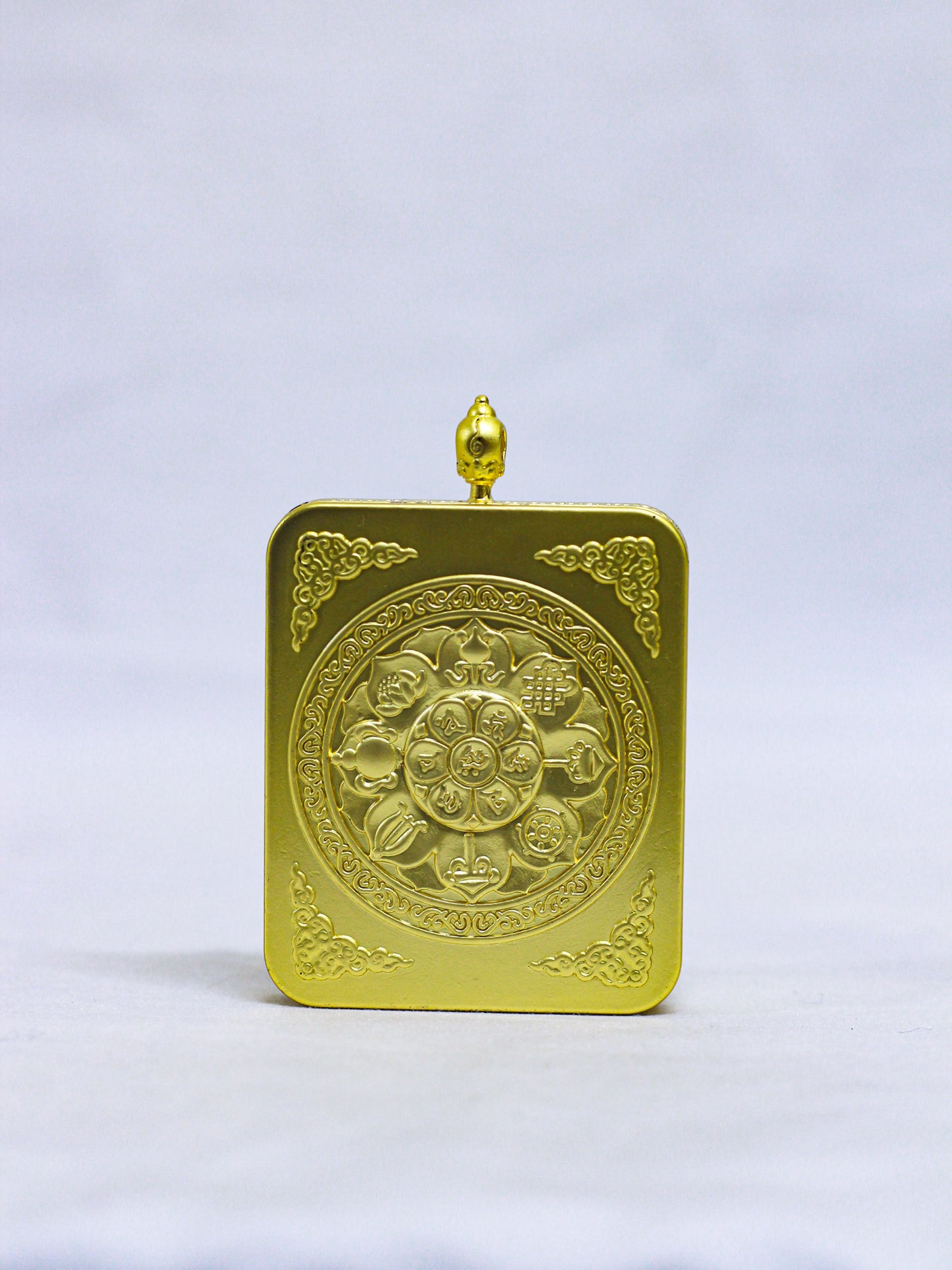 Back of an authentic Chenrezig Thangka Ghau locket engraved with a sacred Lotus Mandala, Eight Auspicious Symbols, floral corner motifs, and a decorative red coral-style stone.