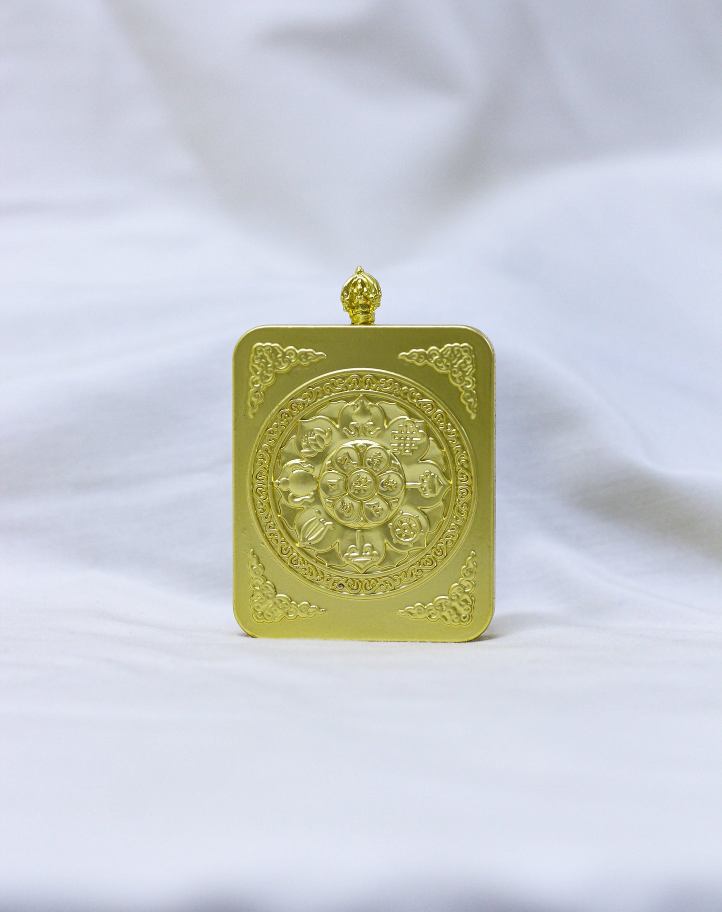 Back profile of the Mahakala thangka pendant locket with an embossed Ashtamangala (eight auspicious symbols) and decorative corner flourishes