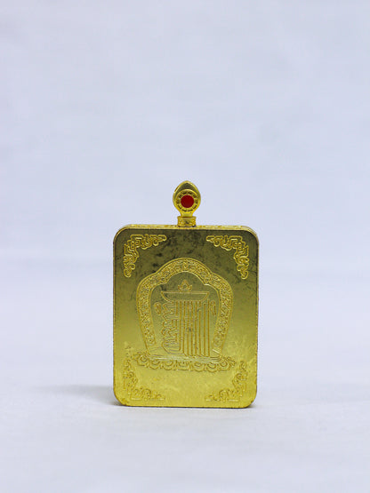 Back of an authentic Green tara thangka locket engraved with the sacred Kalachakra Namchu Wangden emblem, lotus petal, ornate temple arch, floral corner motifs, and a red coral-style stone of the decorative bail 