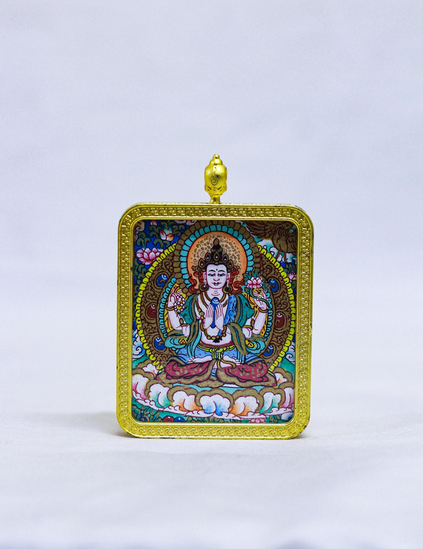 Hand-painted Chenrezig Thangka locket in a traditional Tibetan Ghau pendant featuring a gold-tone engraved frame, cloud and wave border, and red coral-style decorative bail.