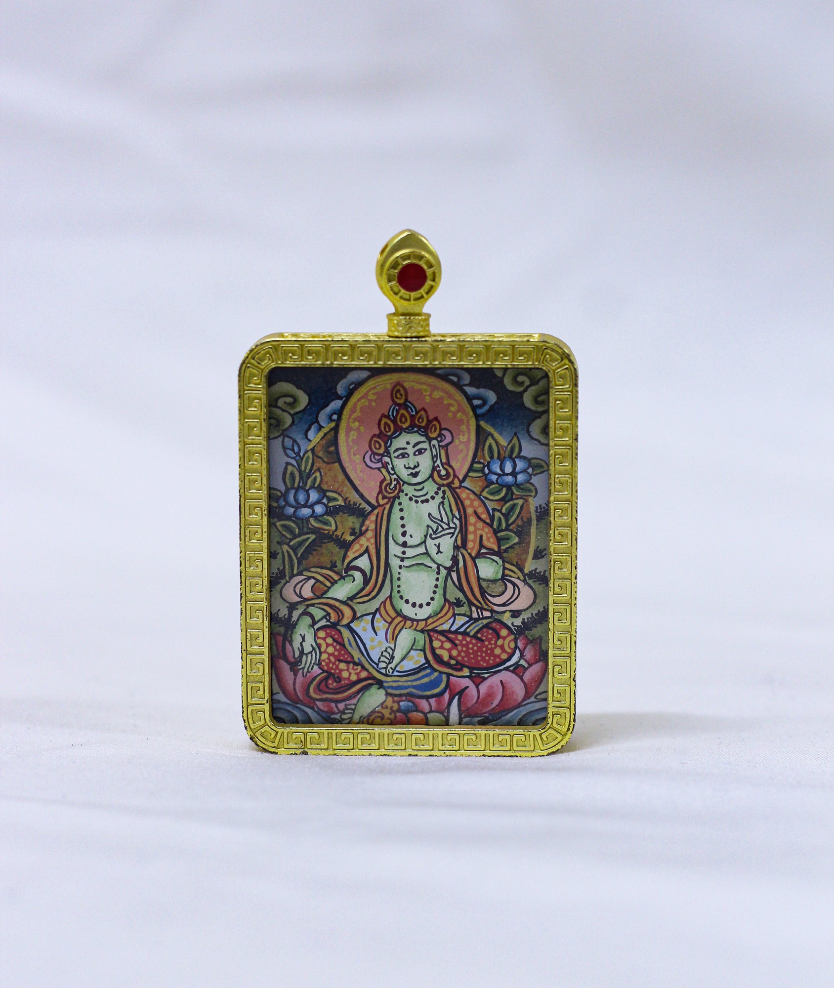 Hand-painted Green Tara thangka locket in a traditional Tibetan Ghau pendant featuring a gold-tone engraved frame, intricate cloud and wave border, red coral-style bail, and authentic Himalayan Buddhist craftmanship