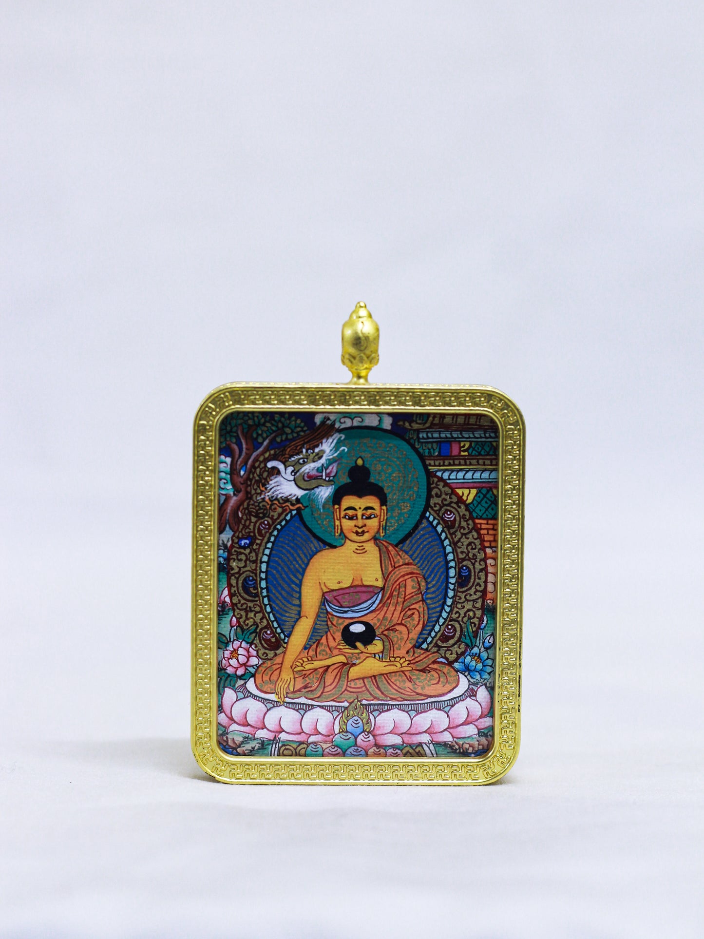Hand-painted Shakyamuni Buddha butti thangka pendant in a golden locket frame featuring traditional Tibetan sacred art.
