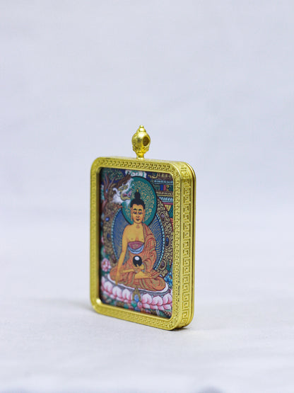 Side profile of the Shakyamuni Buddha butti thangka pendant showing the handcrafted gold locket design and dimensional frame.