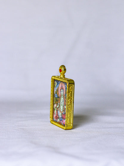 Side profile of a handmade Green Tara Tibetan ghau thangka locket showing engraved Buddhist mantra inscription in traditional script along the gold-tone metal frame with detailed Himalayan craftsmanship.