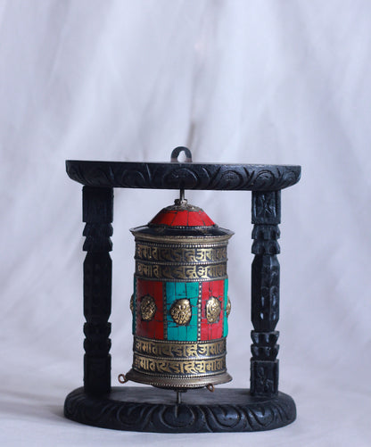 Front View of Tibetan prayer wheel with wooden stand featuring traditional Tibetan inscriptions and colorful detailing