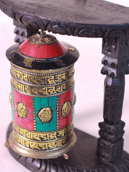 Side view of decorative tibetan prayer wheel featuring Tibetan inscriptions and colorful traditional craftmanship